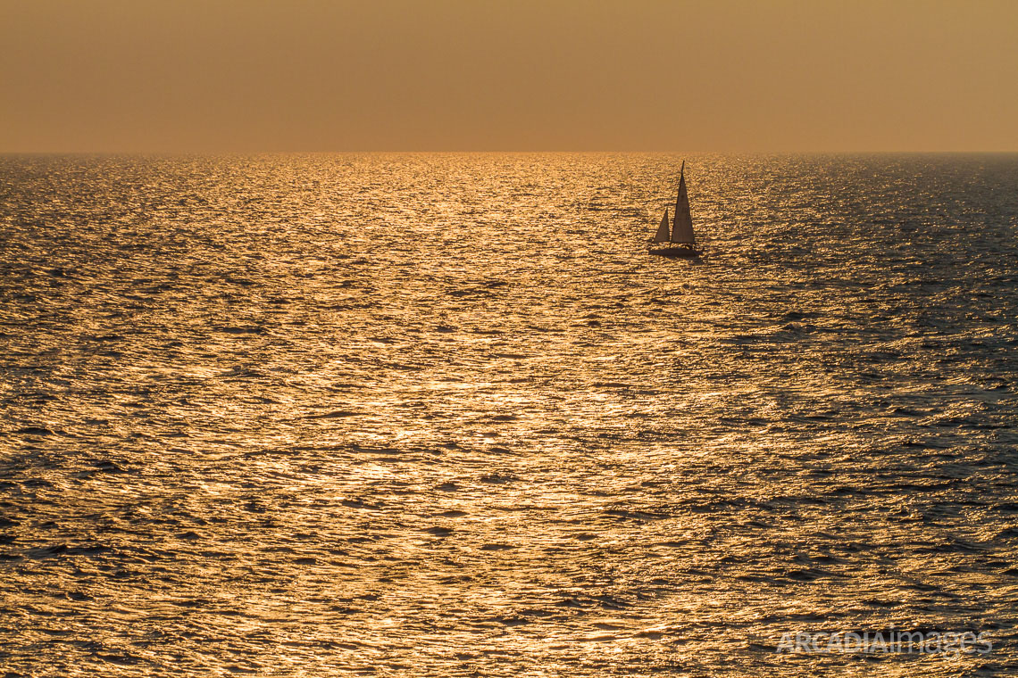 A sailboat sailing close to Cape Maleas during sunrise, Laconia, Peloponnese