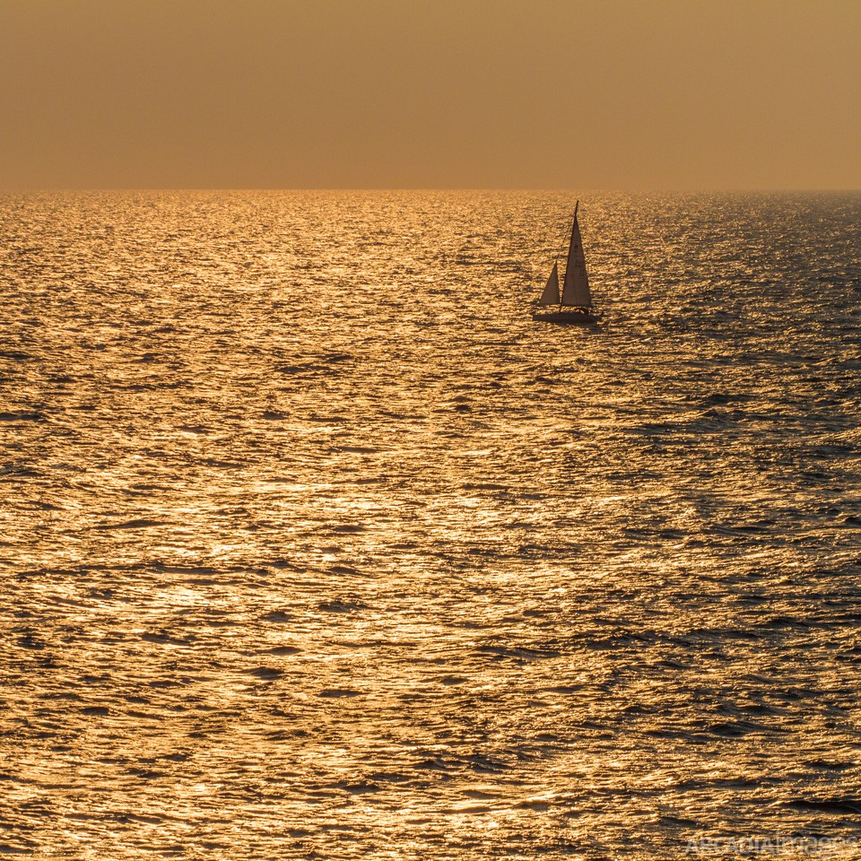 A sailboat sailing close to cape Maleas during sunrise, Laconia, Peloponnese