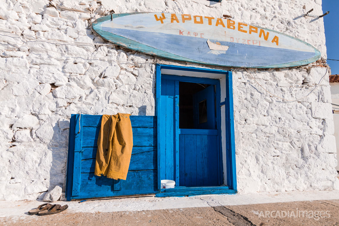 The entrance of a fish tavern with its sign, the fishermans pants and sandals. Aghia Varvara beach, Skoutari, Laconia, Peloponnese