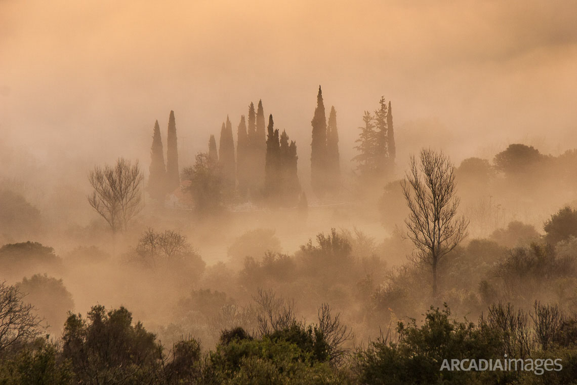 Panagias church and cemetery with morning fog at Pournaria village. Arcadia, Peloponnese, Greece