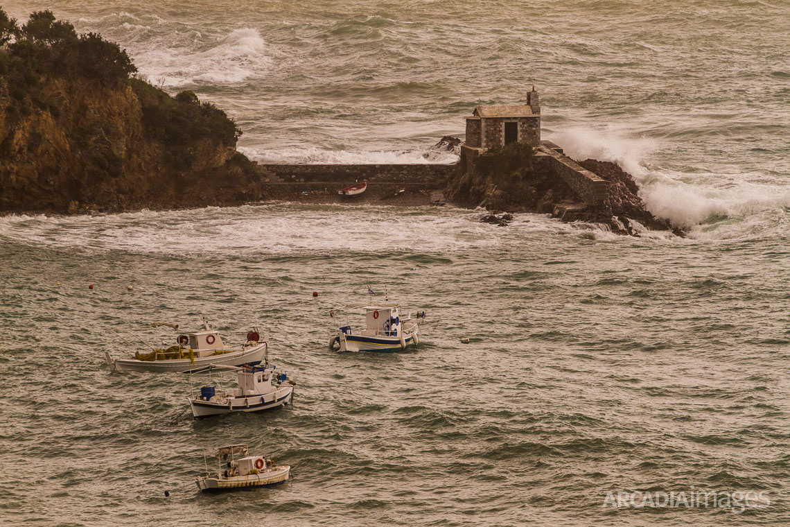 Waves hitting the rocks and the chapel in the small cove near Kotronas village. East Mani, Laconia, Peloponnese